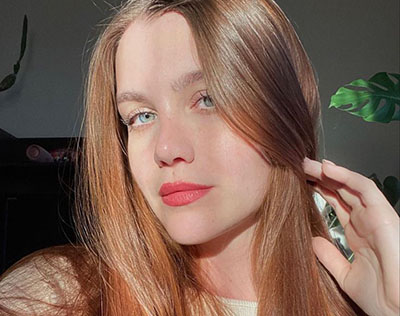 Foto ilustrativa de uma mulher ruiva em retrato, representando uma Sugar Baby.