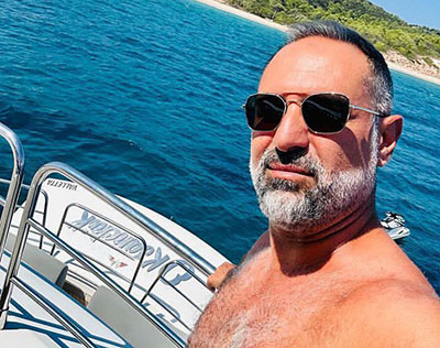 Foto ilustrativa de um homem grisalho em uma lancha, representando um Sugar Daddy.