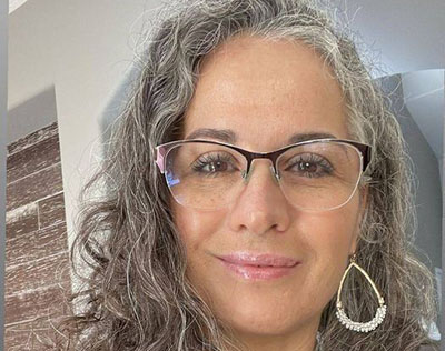 Foto ilustrativa de uma mulher com óculos em retrato, representando uma Sugar Mommy.
