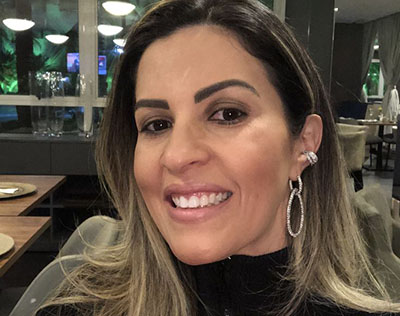 Foto ilustrativa de uma mulher sorrindo em um restaurante, representando uma Sugar Mommy.